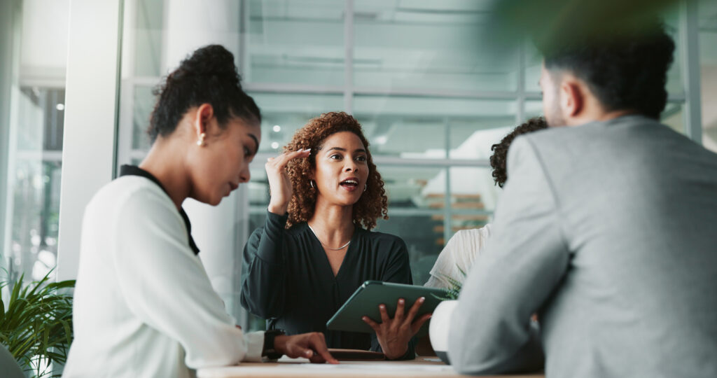 Lawyer with a tablet at a meeting with her team
